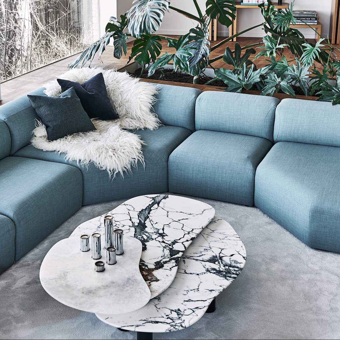 a living room with blue couches and a marble coffee table
