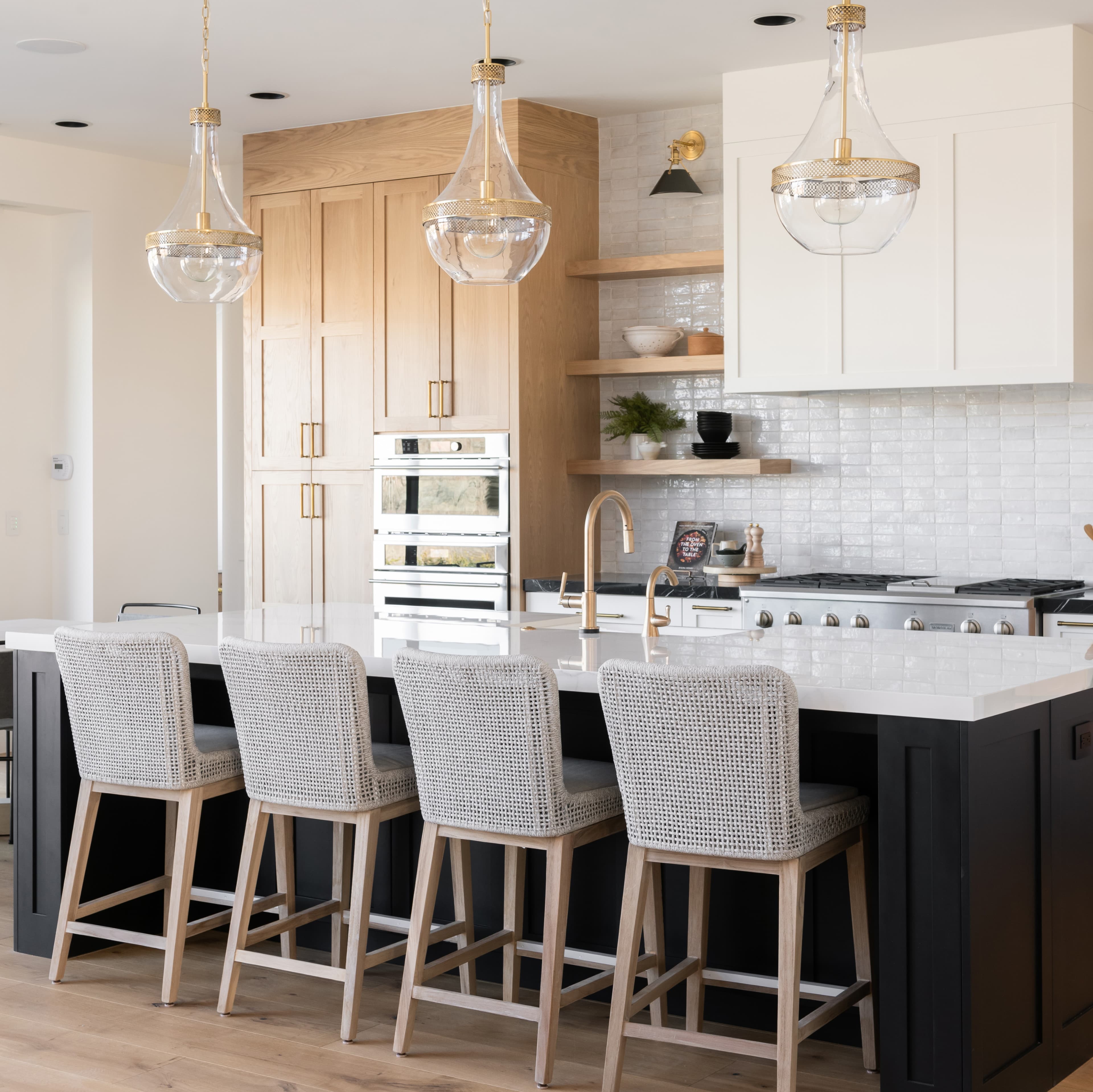 a large kitchen with a center island and bar stools